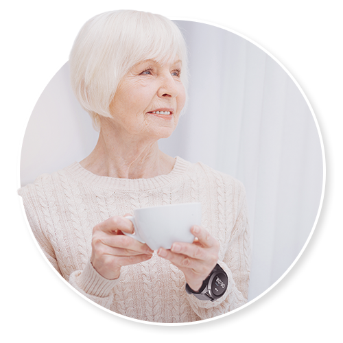An older woman holding a teacup at home, soft natural light
